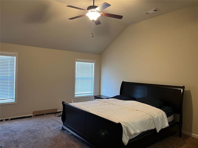 bedroom featuring dark colored carpet, visible vents, multiple windows, and lofted ceiling