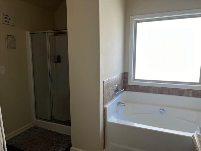 bathroom featuring a stall shower and a garden tub