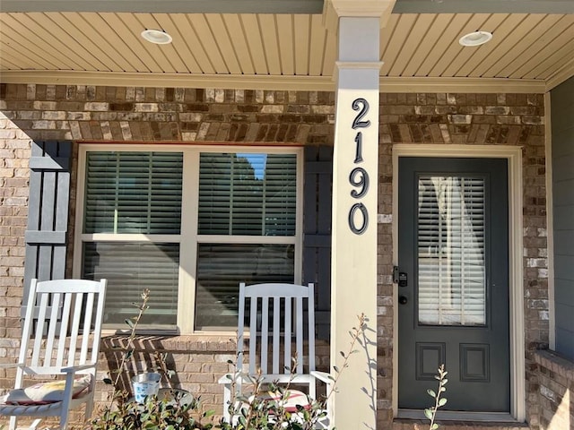 doorway to property with brick siding