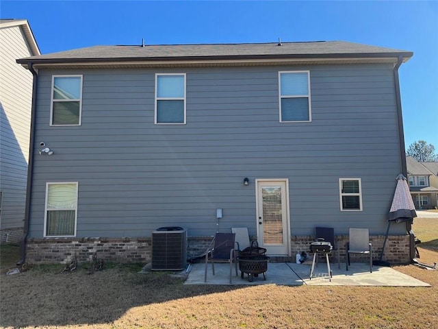 rear view of house featuring central air condition unit, a patio area, an outdoor fire pit, and a yard