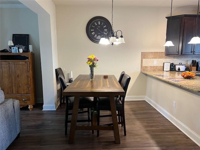 dining space featuring a chandelier, dark wood-style flooring, and baseboards