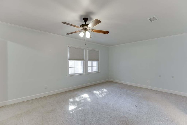 empty room featuring light colored carpet, crown molding, baseboards, visible vents, and ceiling fan