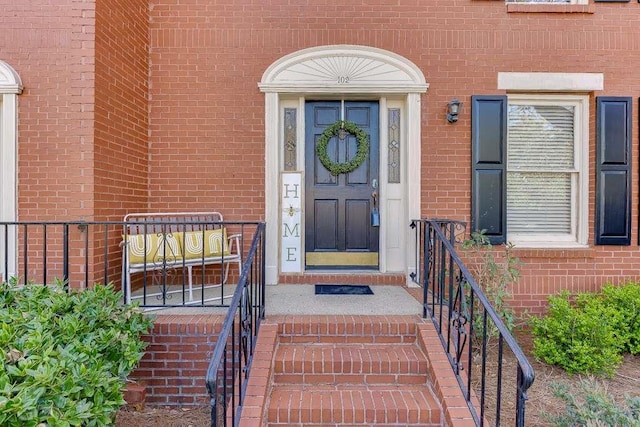 doorway to property with brick siding