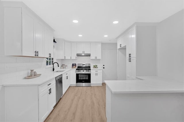 5689 Woodland Dr, Acworth, GA 30102 - kitchen featuring stainless steel appliances, light wood-style flooring, tasteful backsplash, a peninsula, and recessed lighting