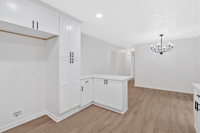 5689 Woodland Dr, Acworth, GA 30102 - kitchen with a peninsula, light wood finished floors, light countertops, a chandelier, and recessed lighting