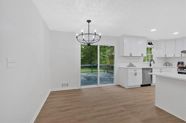 5689 Woodland Dr, Acworth, GA 30102 - kitchen featuring stainless steel appliances, a chandelier, white cabinetry, light countertops, and light wood-style flooring