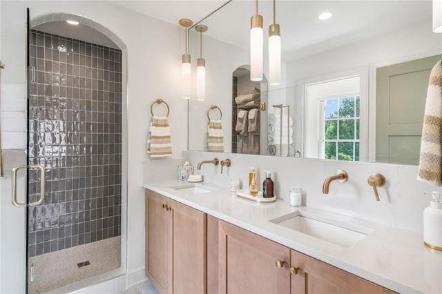 bathroom featuring double vanity, a shower stall, and a sink