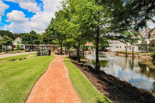 view of property's community featuring a water view and a yard