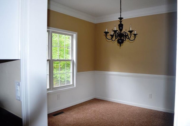 spare room with crown molding, visible vents, carpet flooring, a chandelier, and baseboards