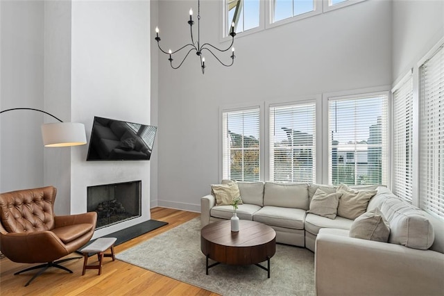 155 Breakspear Ln, Fayetteville, GA 30214 - living room with light wood finished floors, a high ceiling, a chandelier, a fireplace with raised hearth, and baseboards