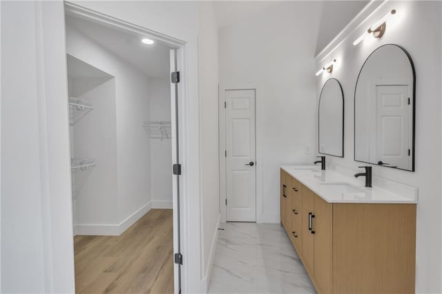 2601 Garland Way, Duluth, GA 30096 - bathroom featuring double vanity, baseboards, a walk in closet, and marble finish flooring