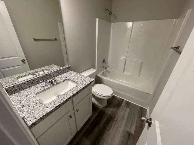 115 Deer Xing, Temple, GA 30179 - full bath featuring toilet, wood finished floors, vanity, and bathing tub / shower combination