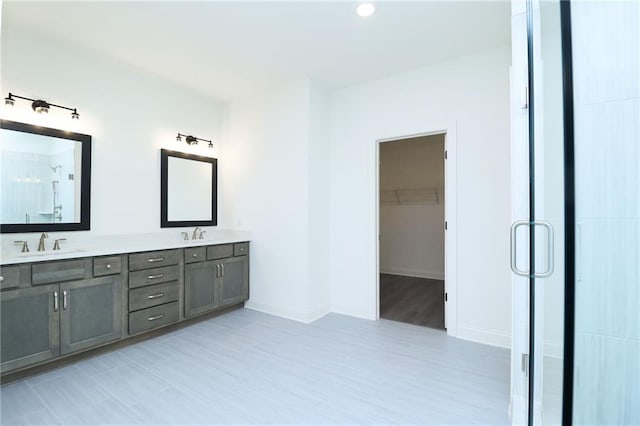 2109 Ella Springs Dr, Covington, GA 30014 - full bathroom featuring double vanity, a shower stall, a walk in closet, baseboards, and wood finished floors