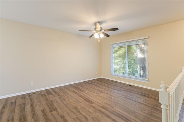 unfurnished room with dark hardwood / wood-style floors and ceiling fan