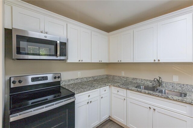 kitchen featuring stainless steel appliances, sink, and white cabinets