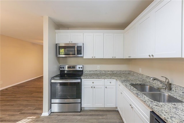 kitchen featuring sink, appliances with stainless steel finishes, dark hardwood / wood-style floors, and white cabinetry