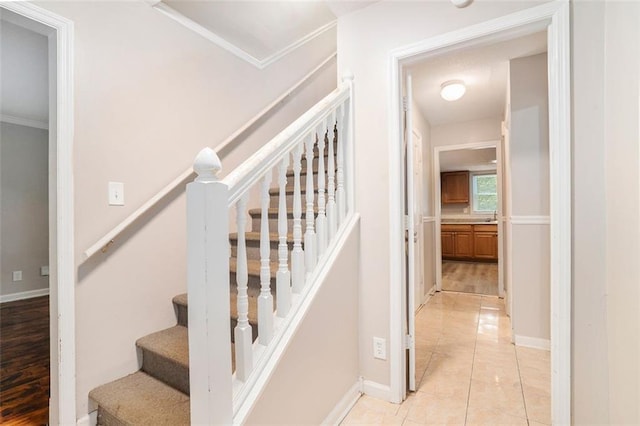 stairs with ornamental molding and wood-type flooring