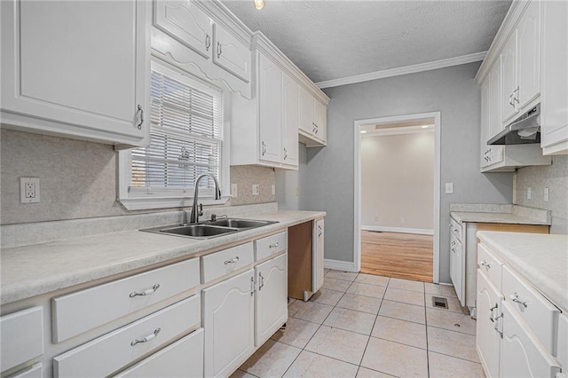 kitchen featuring a textured ceiling, white cabinetry, light tile patterned flooring, ornamental molding, and sink