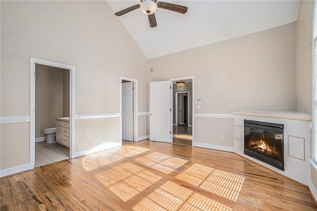 unfurnished living room with ceiling fan, light hardwood / wood-style flooring, and high vaulted ceiling