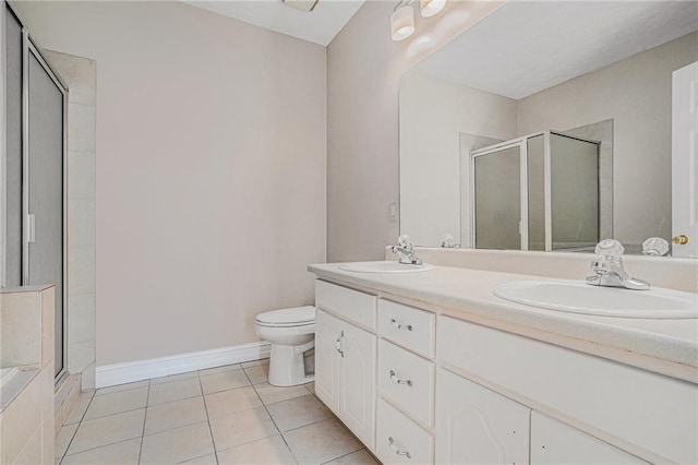 bathroom with toilet, a shower with door, tile patterned floors, and vanity