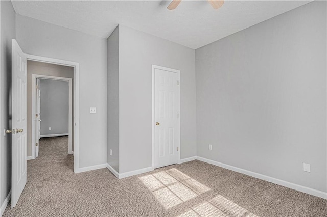 unfurnished bedroom featuring ceiling fan, light colored carpet, and a closet