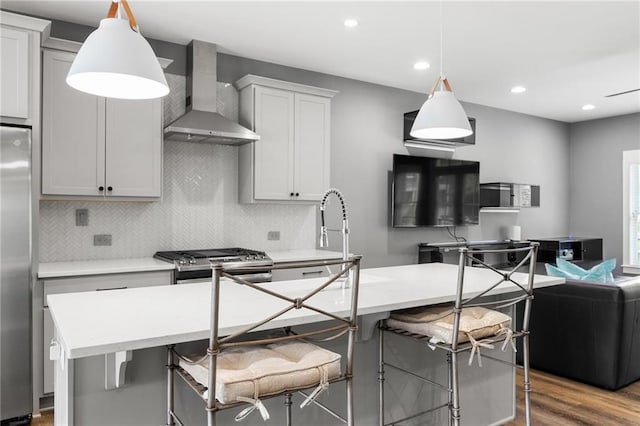 3484 Orchard St, Atlanta, GA 30354 - kitchen with wall chimney range hood, stainless steel appliances, decorative backsplash, light countertops, and a center island with sink