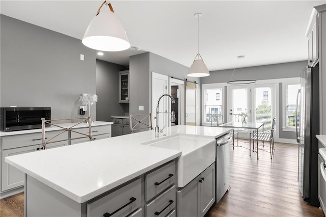 3484 Orchard St, Atlanta, GA 30354 - kitchen featuring gray cabinets, an island with sink, appliances with stainless steel finishes, light countertops, and dark wood-style floors