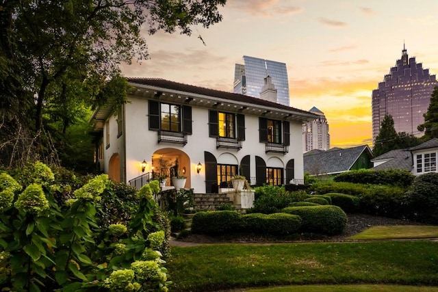 view of front of house featuring a balcony and a yard