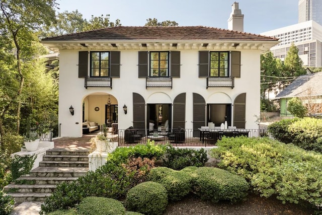 back of house featuring a balcony, a porch, and french doors