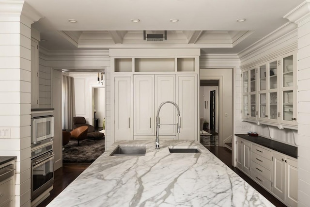 kitchen with appliances with stainless steel finishes, light stone countertops, sink, and dark hardwood / wood-style flooring