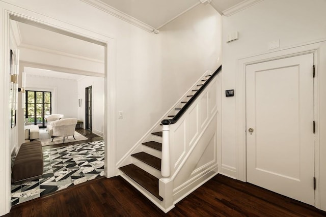 stairway with crown molding and hardwood / wood-style floors