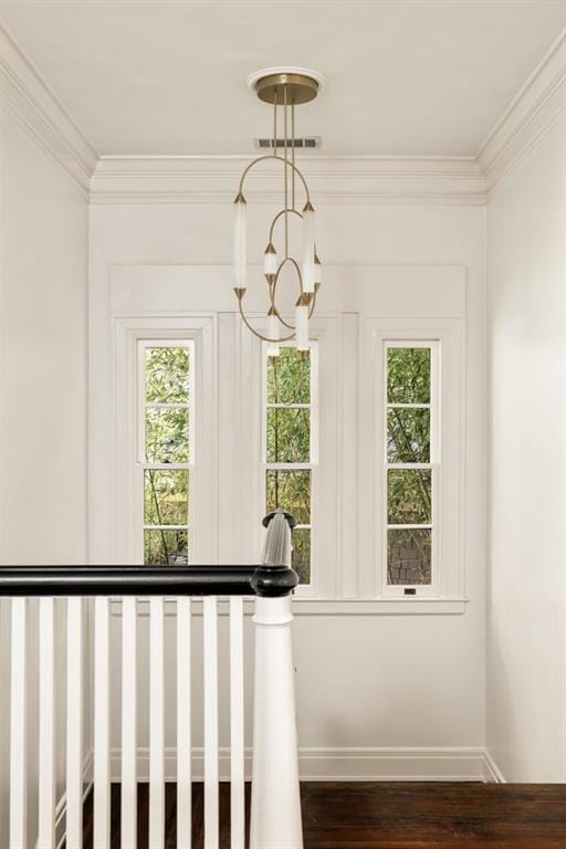 staircase with a notable chandelier, crown molding, and hardwood / wood-style flooring