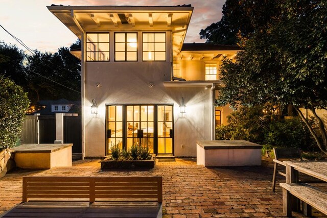 back house at dusk with a patio area