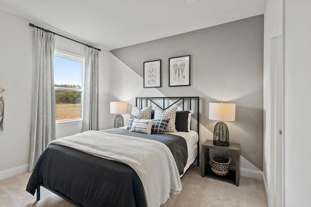 bedroom with light colored carpet and vaulted ceiling