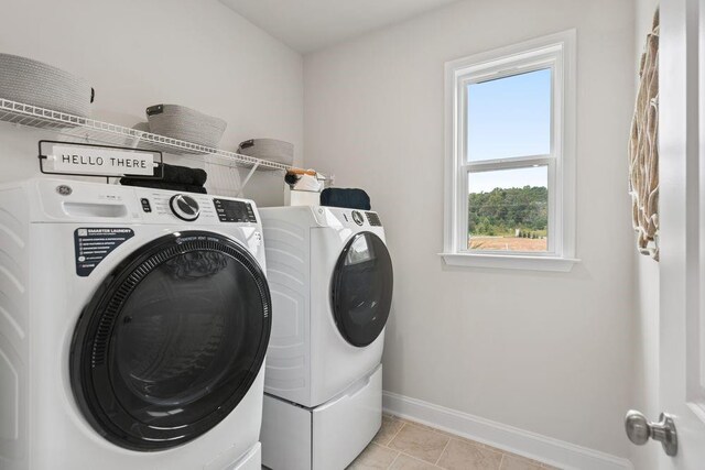 clothes washing area featuring light tile patterned floors and independent washer and dryer