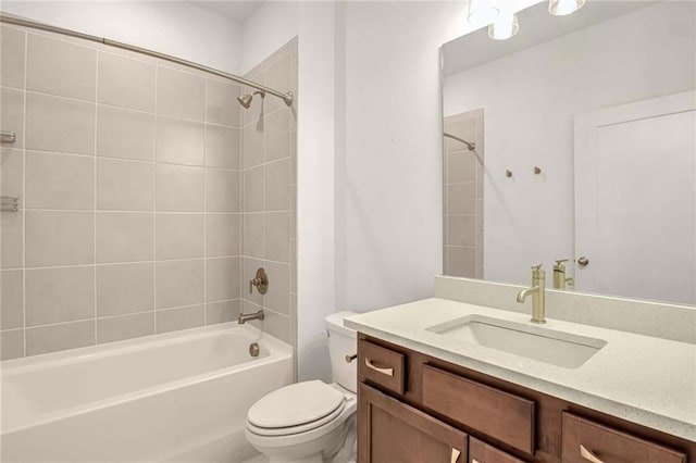 full bathroom featuring vanity, tiled shower / bath combo, and toilet