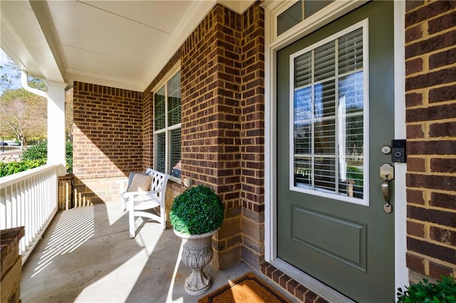 view of exterior entry featuring covered porch