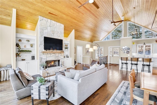 living room with wood ceiling, wood finished floors, built in shelves, high vaulted ceiling, and a fireplace