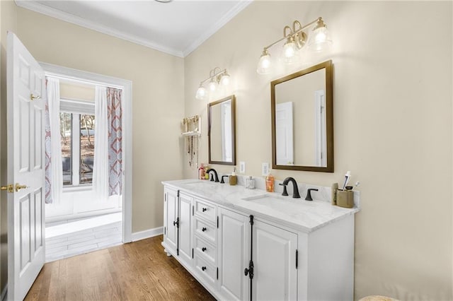 full bathroom with ornamental molding, double vanity, a sink, and wood finished floors