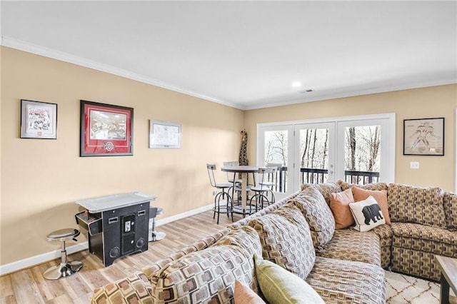 living area with crown molding, baseboards, and wood finished floors