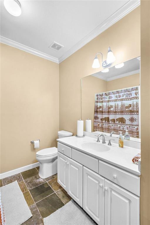 full bathroom featuring toilet, visible vents, and crown molding