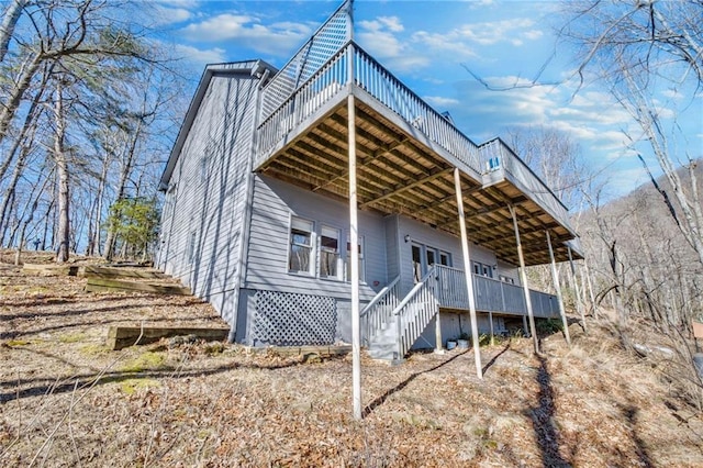 view of property exterior with a wooden deck and stairs