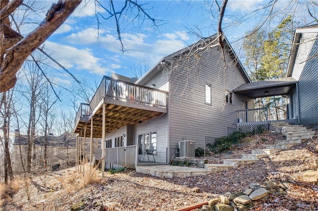 view of side of home featuring stairs, central AC, a patio, and a wooden deck