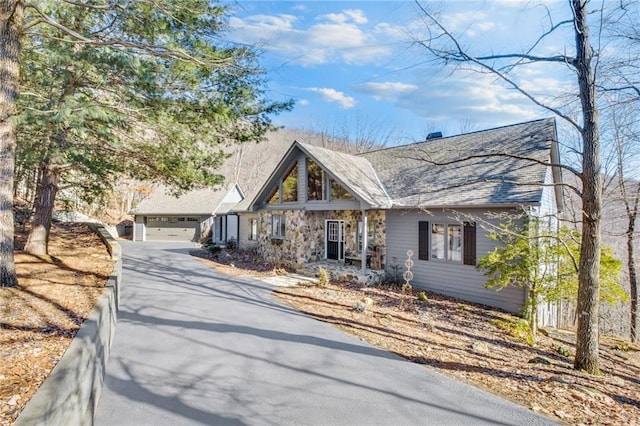 view of front facade featuring stone siding and a detached garage