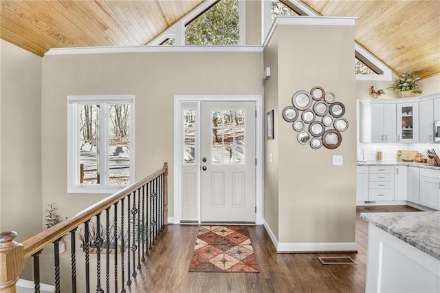 entryway with wooden ceiling, a healthy amount of sunlight, and dark wood finished floors