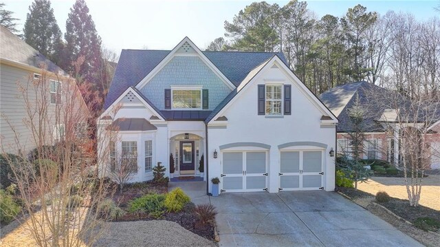3355 Olivia Ct, Cumming, GA 30041 - view of front facade featuring driveway, a garage, a standing seam roof, stucco siding, and metal roof