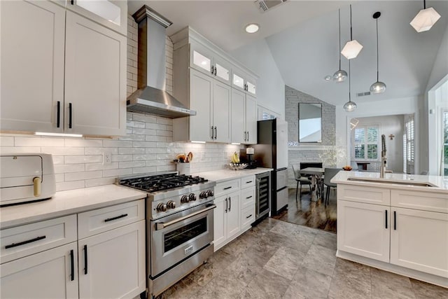 3355 Olivia Ct, Cumming, GA 30041 - kitchen with high end stainless steel range, wall chimney exhaust hood, a sink, light countertops, and wine cooler