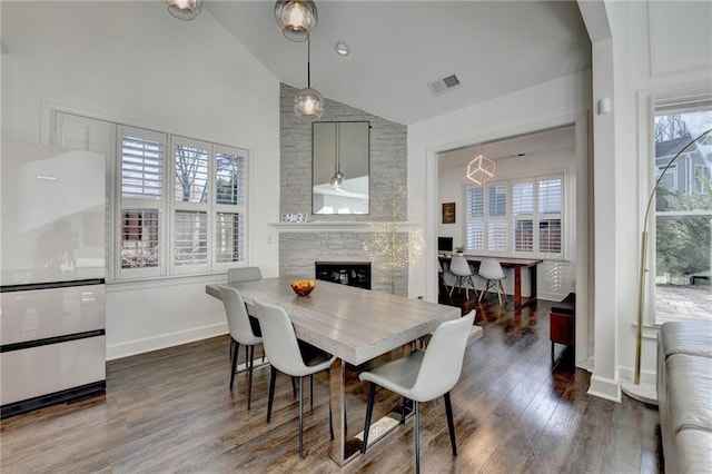 3355 Olivia Ct, Cumming, GA 30041 - dining room with healthy amount of natural light, dark wood-style flooring, a fireplace, baseboards, and high vaulted ceiling