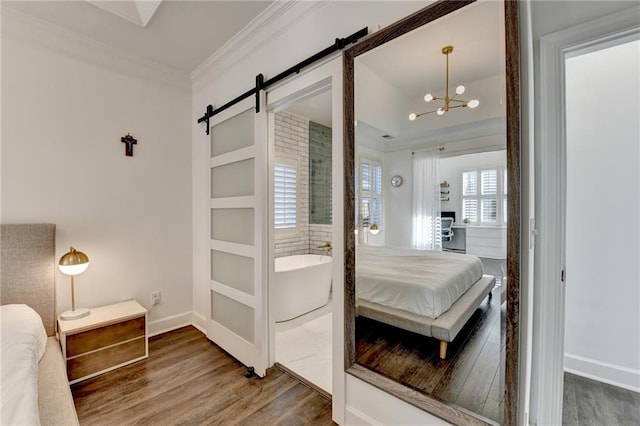 3355 Olivia Ct, Cumming, GA 30041 - bedroom featuring a barn door, crown molding, wood finished floors, a chandelier, and baseboards