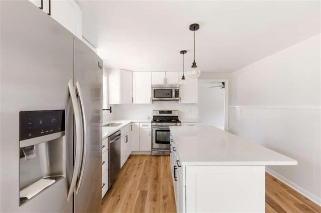 kitchen with white cabinets, pendant lighting, and appliances with stainless steel finishes